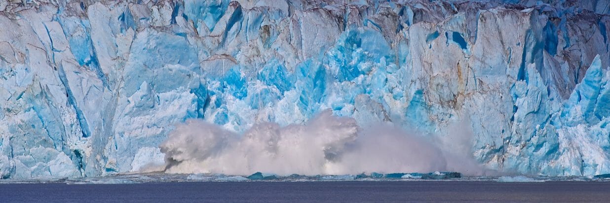 A calving tidewater glacier crashes down